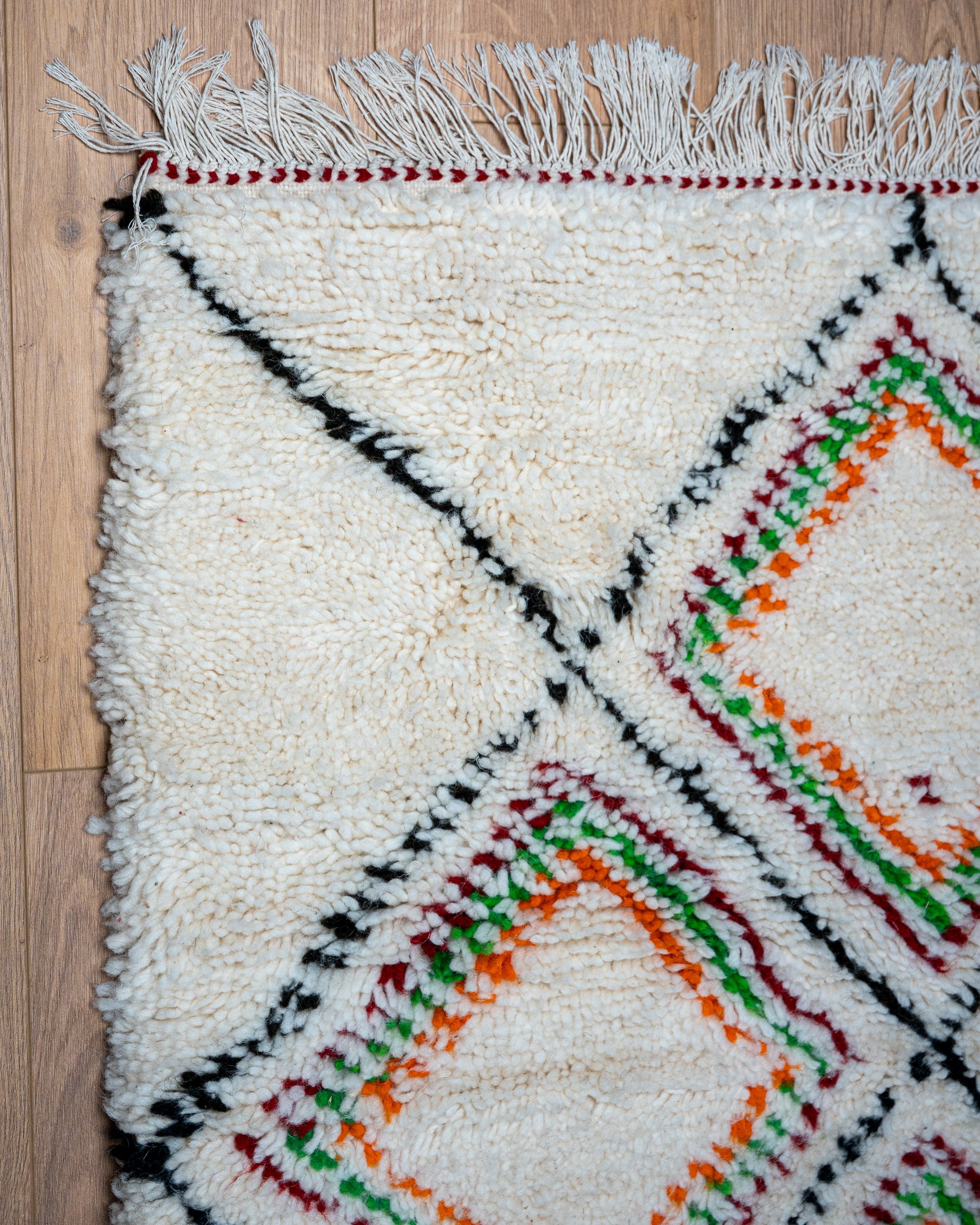 Weißer moderner designer Teppich in Orange, grün, rot schwarz.